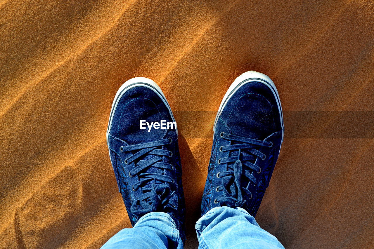 Low section of man wearing shoes standing outdoors