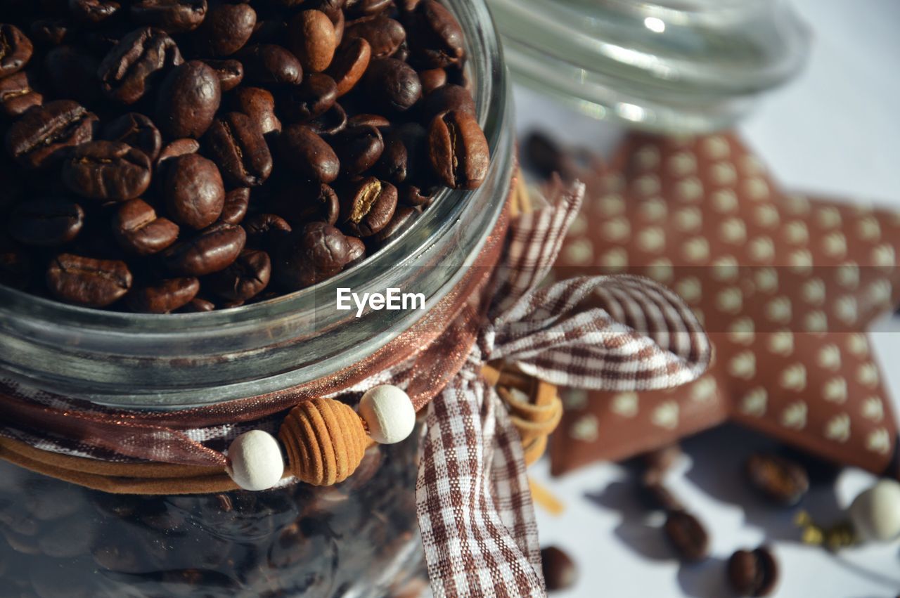 Close-up of roasted coffee beans in decorated jar on table