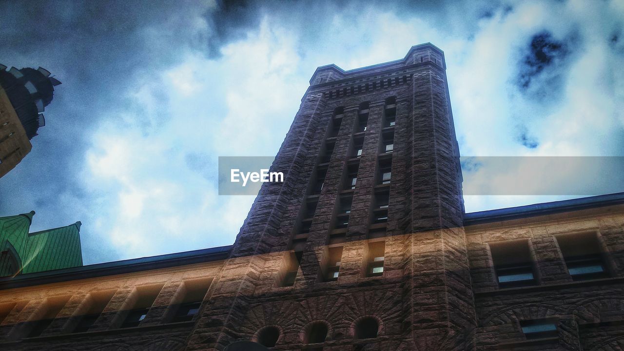 LOW ANGLE VIEW OF BUILT STRUCTURES AGAINST CLOUDY SKY