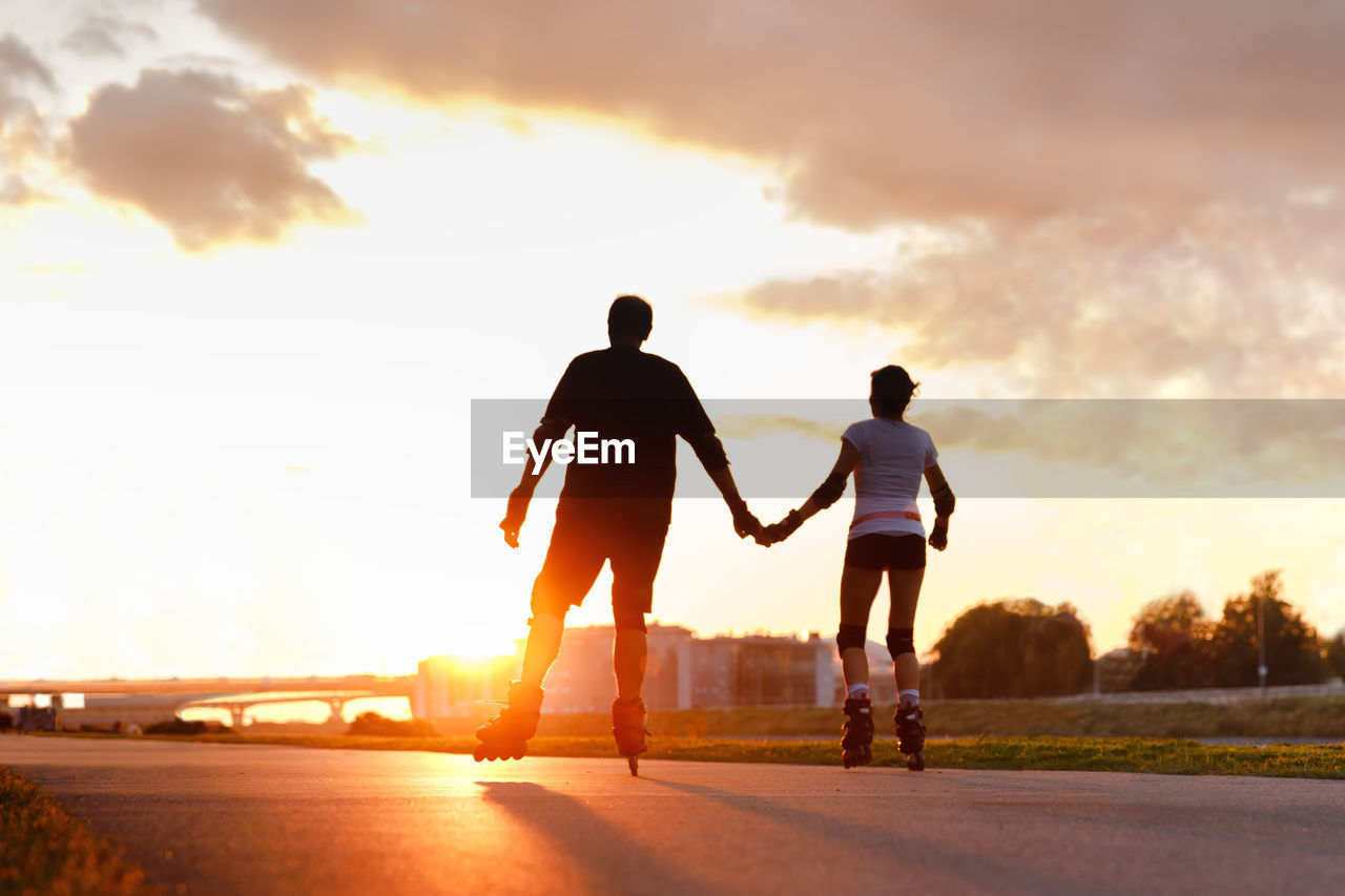 REAR VIEW OF SILHOUETTE MAN AND SON AGAINST SKY DURING SUNSET