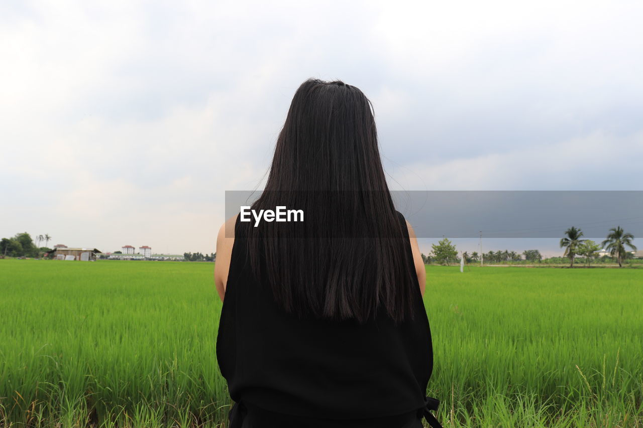 Rear view of woman on agricultural field