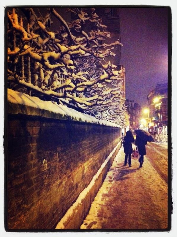 PEOPLE WALKING ON ILLUMINATED STREET