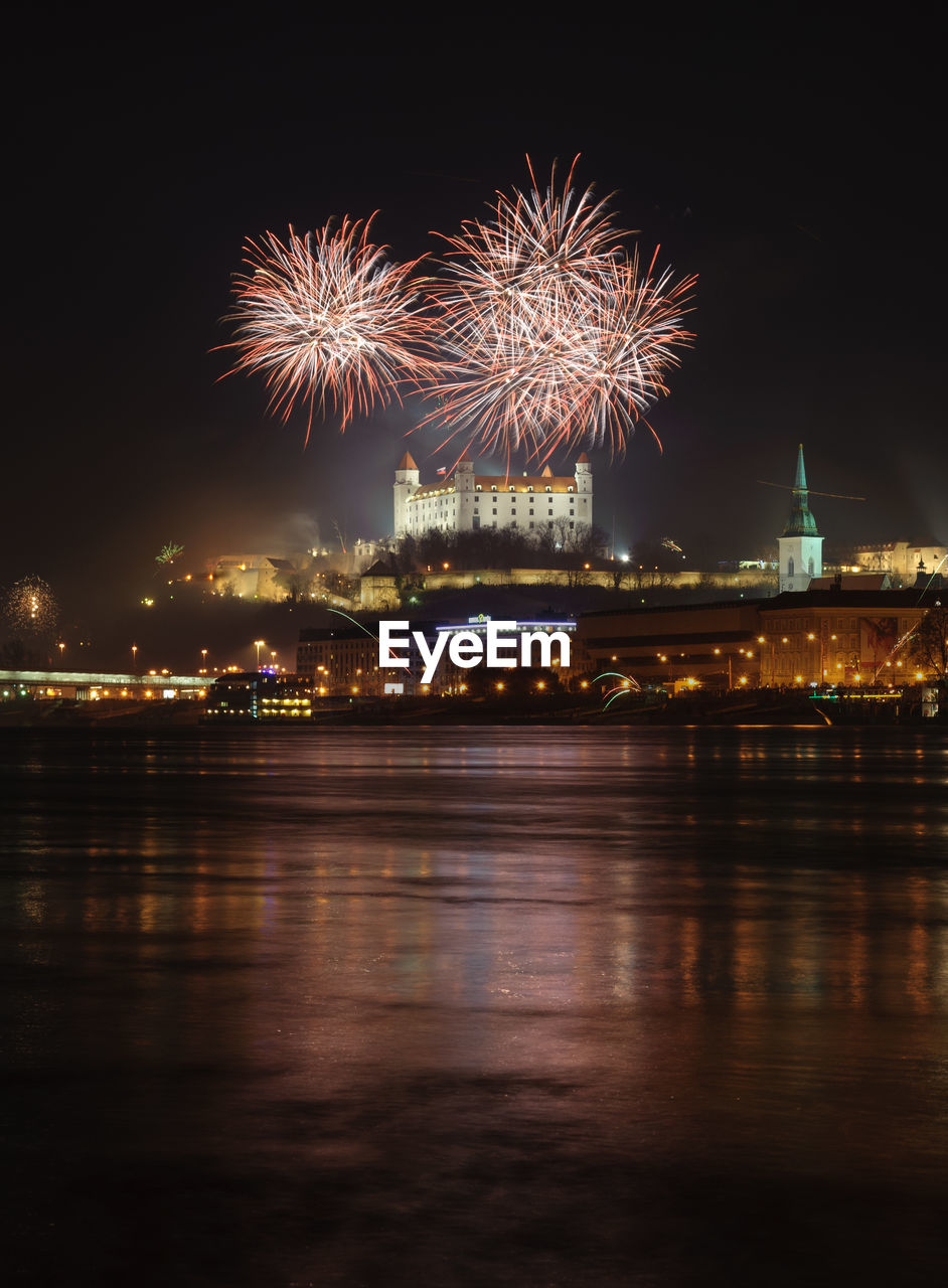 FIREWORK DISPLAY OVER RIVER AGAINST SKY