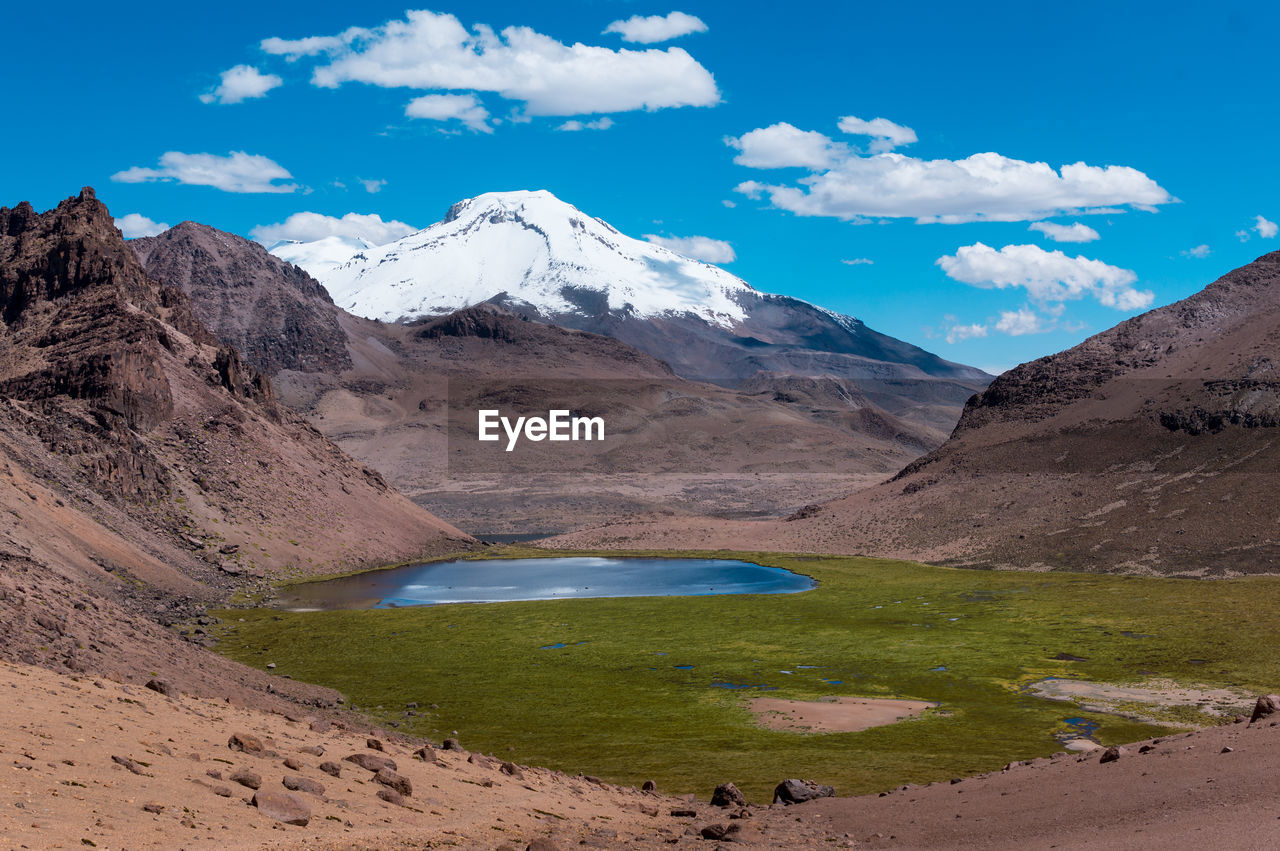 Scenic view of lake by mountains against sky