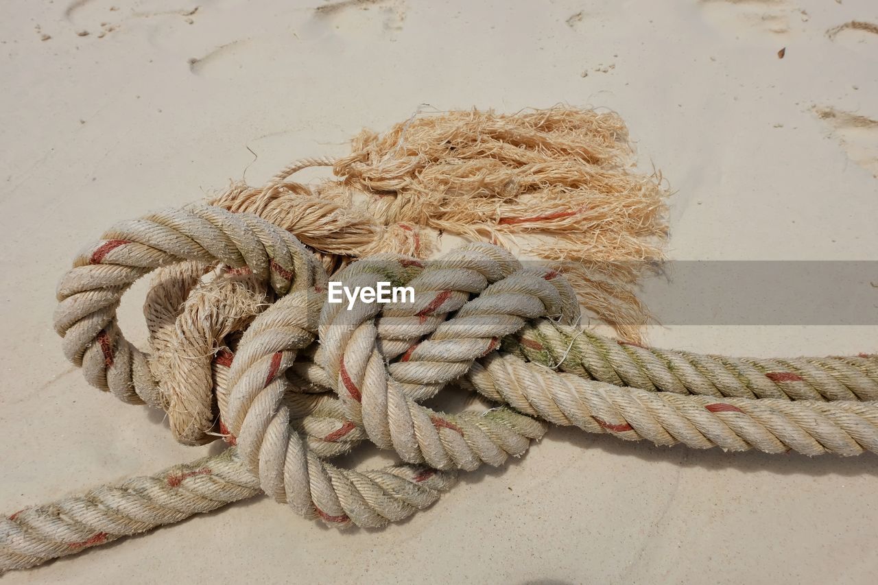 High angle view of rope tied on sandy beach