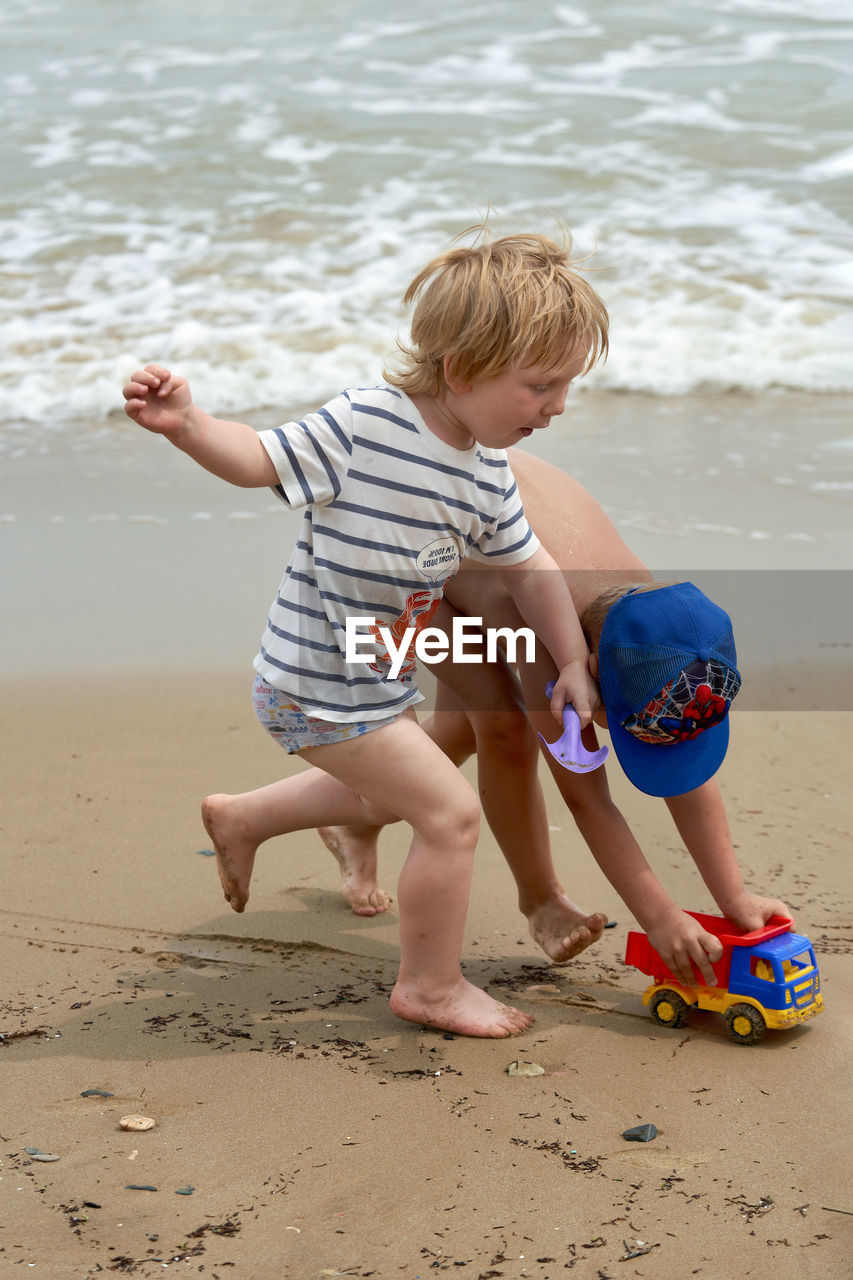 BOYS PLAYING ON BEACH