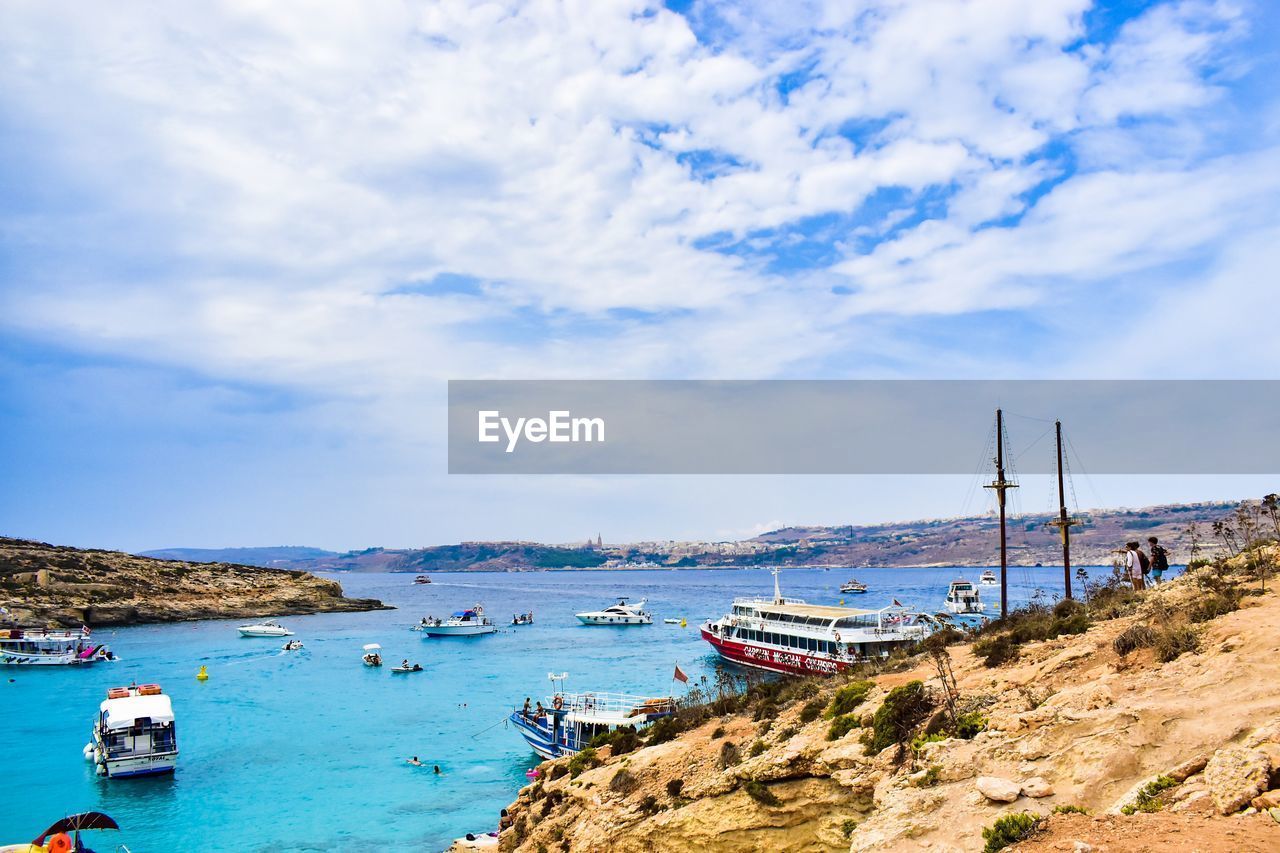 Sailboats moored on sea against sky