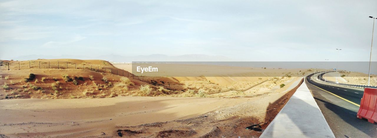 PANORAMIC VIEW OF ROAD ON DESERT AGAINST SKY