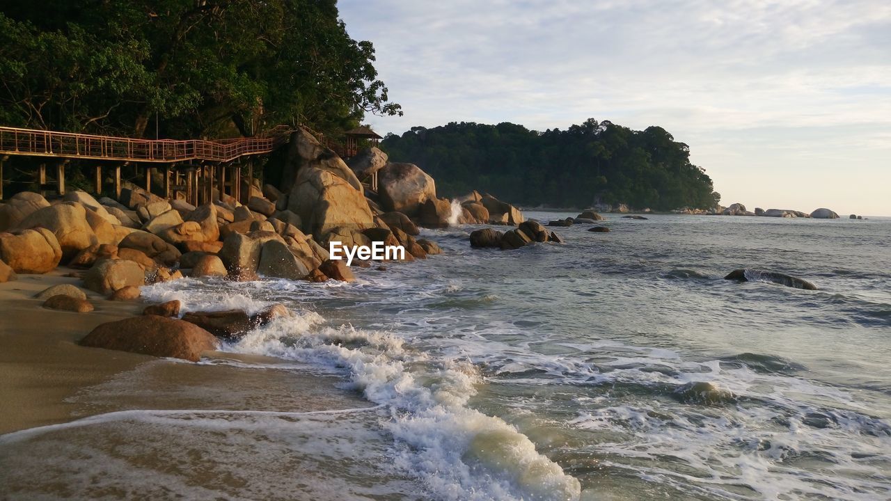 ROCKS ON BEACH AGAINST SKY