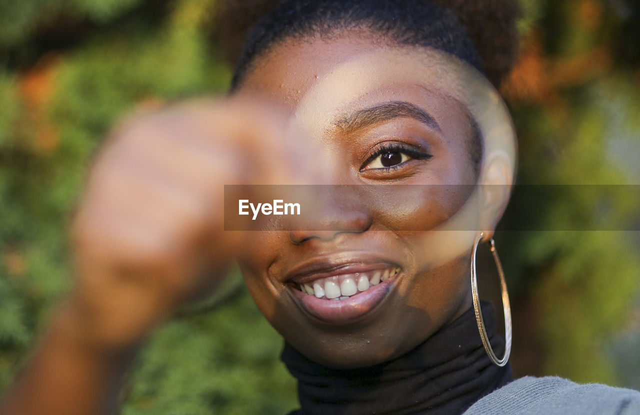 Portrait of smiling young woman seen through earring