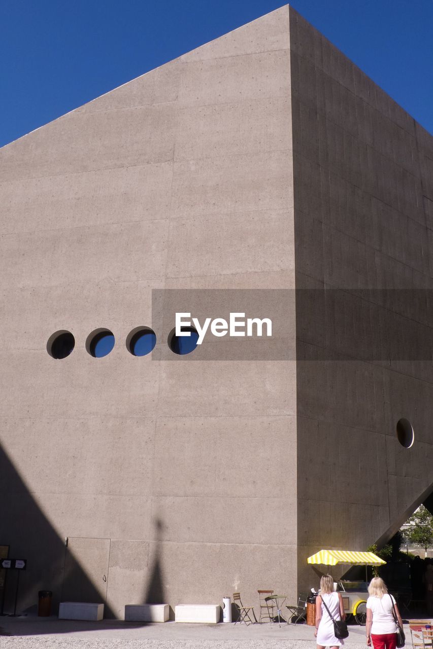 LOW ANGLE VIEW OF MODERN BUILDING AGAINST CLEAR BLUE SKY