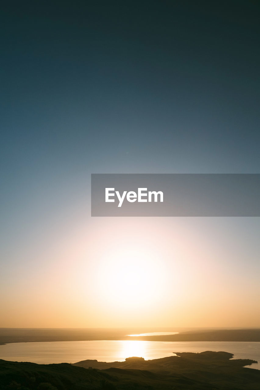 Scenic view of sea against clear sky during sunset