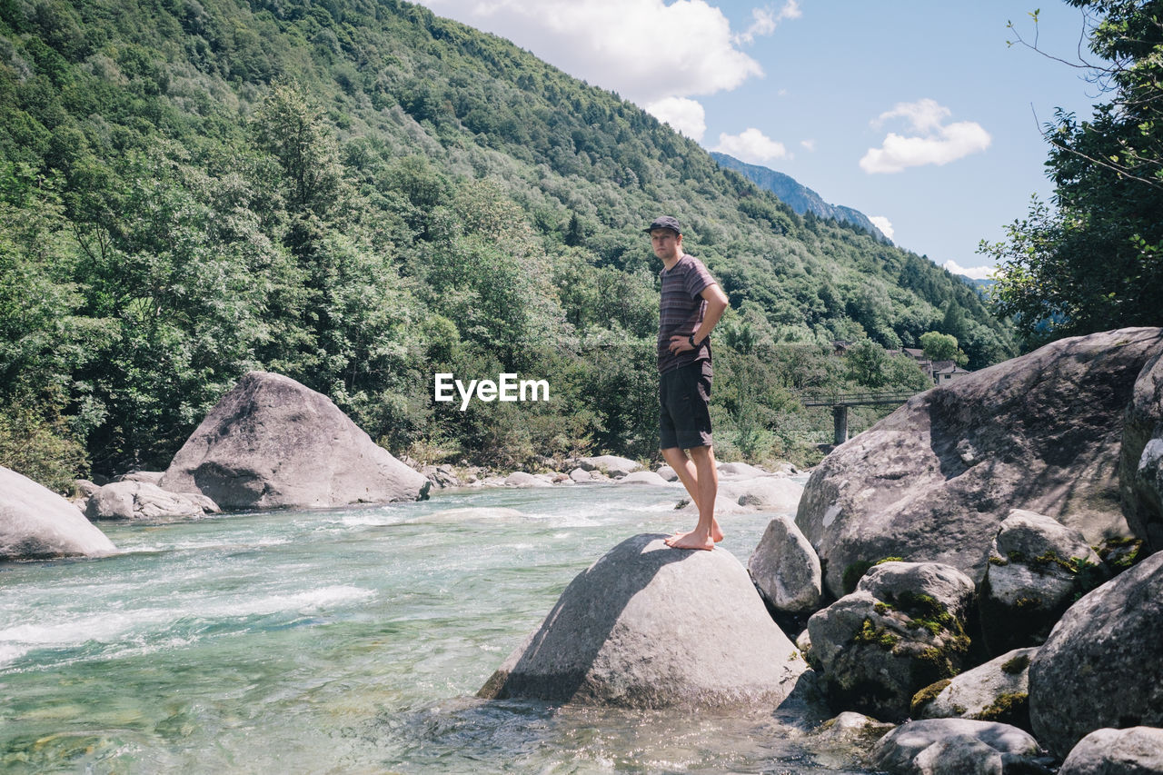 Full length of man on rocks against mountains