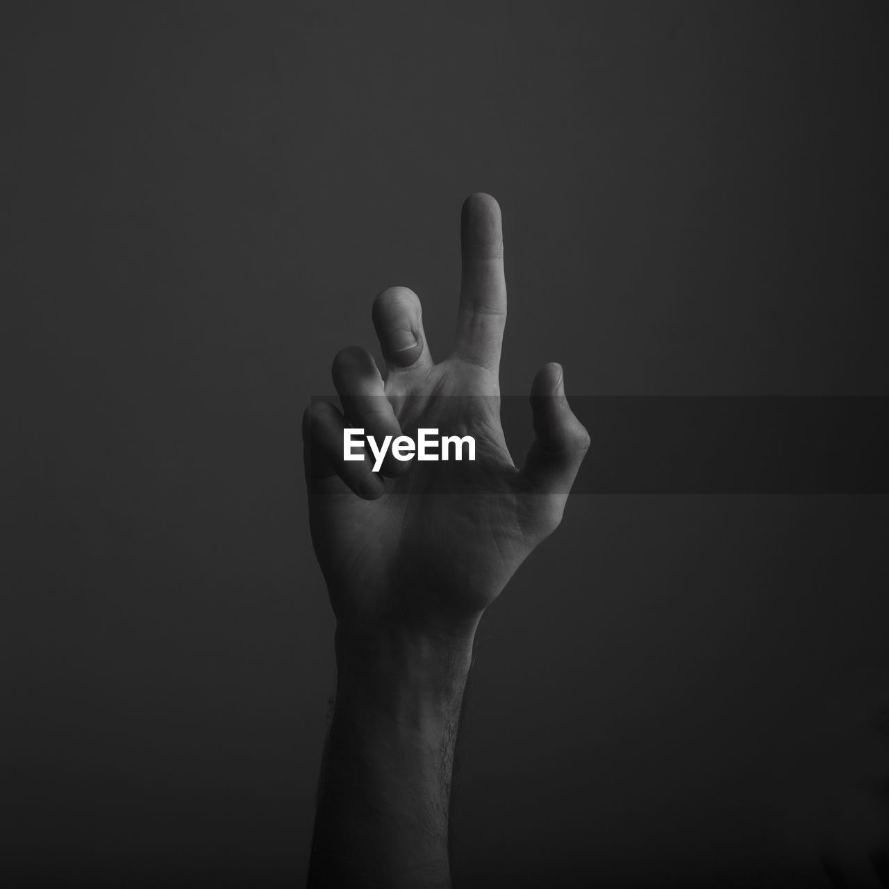 Close-up of human hand gesturing against black background