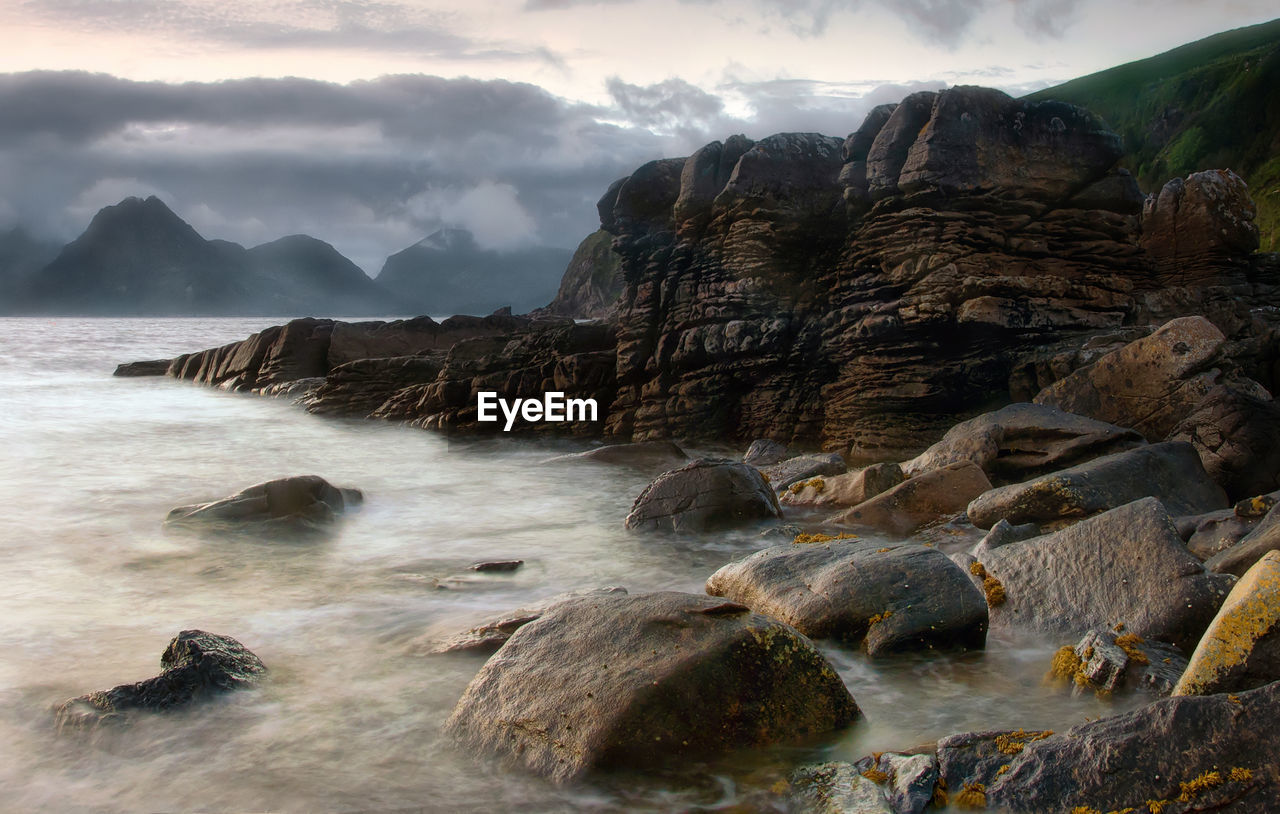 Rocks in sea against sky