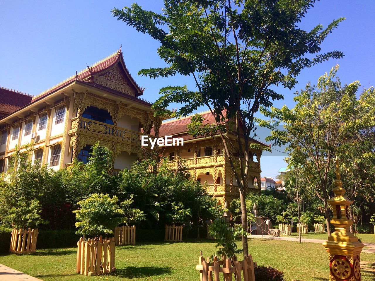 TREES BY TEMPLE AGAINST SKY