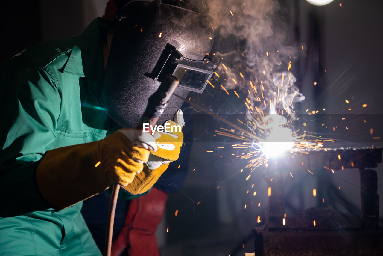 MAN WORKING ON ILLUMINATED FIRE