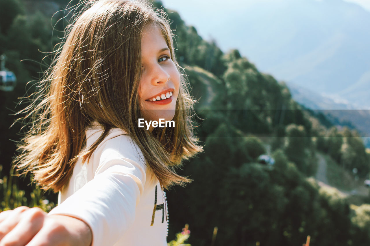 Portrait of smiling girl against sky