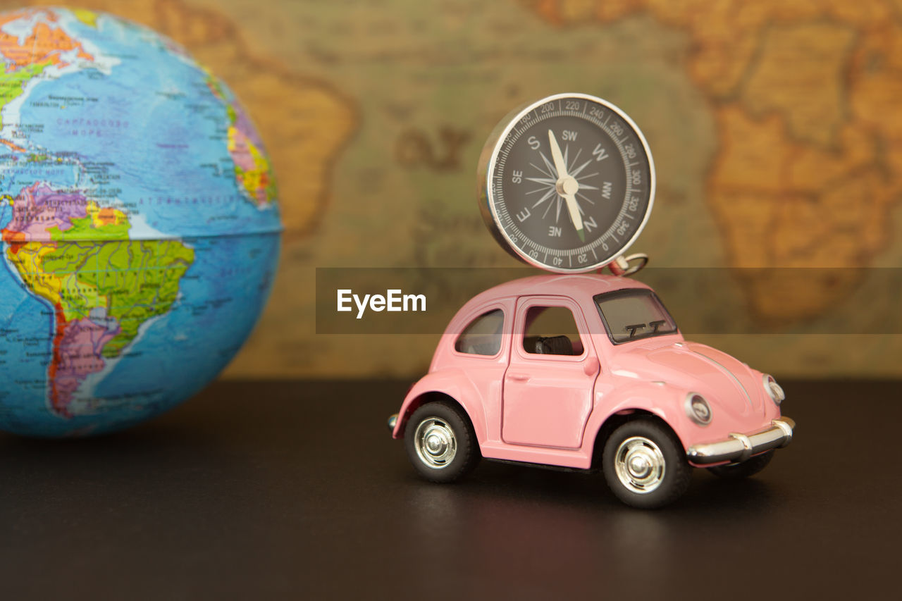 Close-up of toy car and navigational compass on table