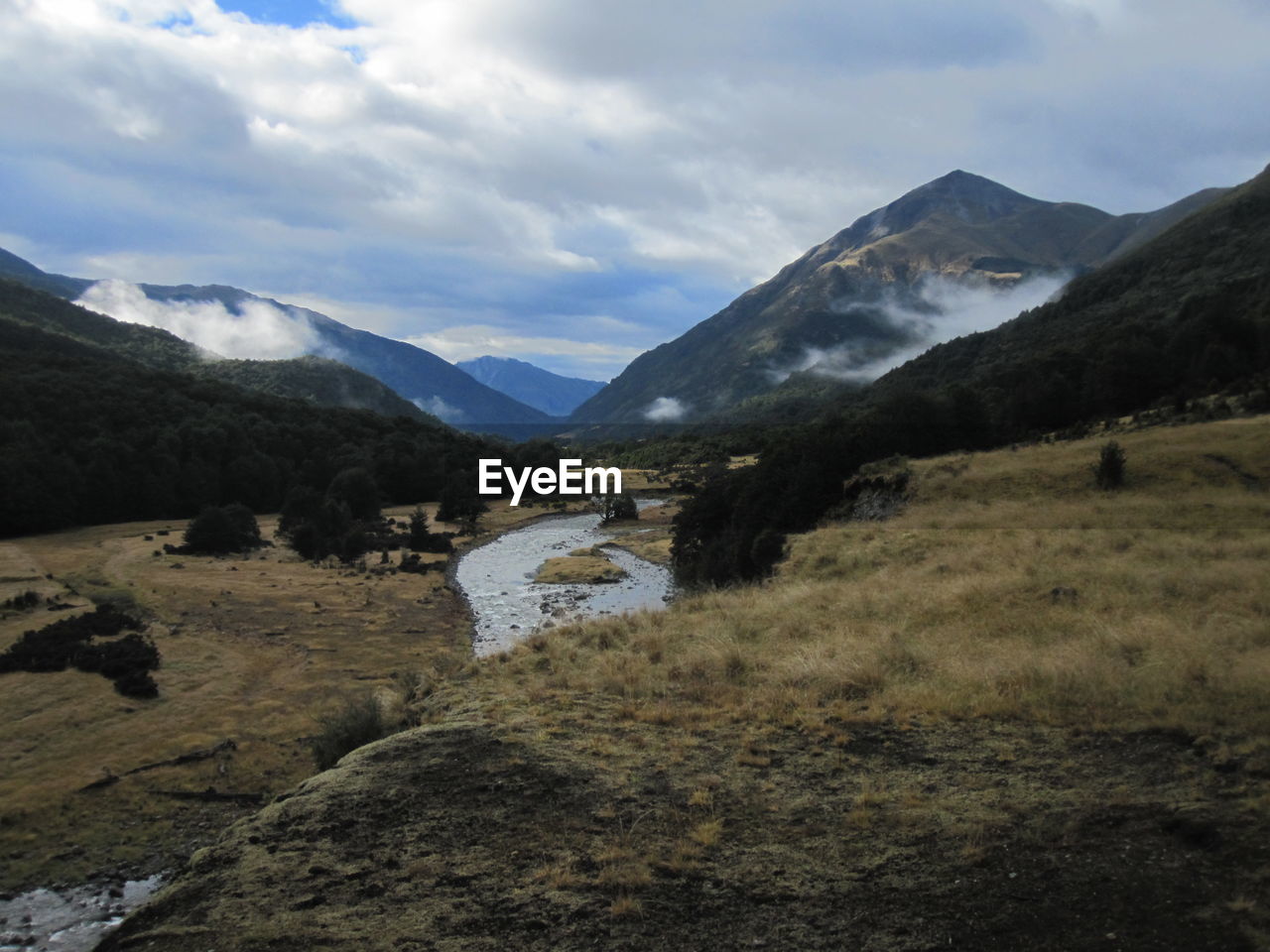 Scenic view of mountains against cloudy sky