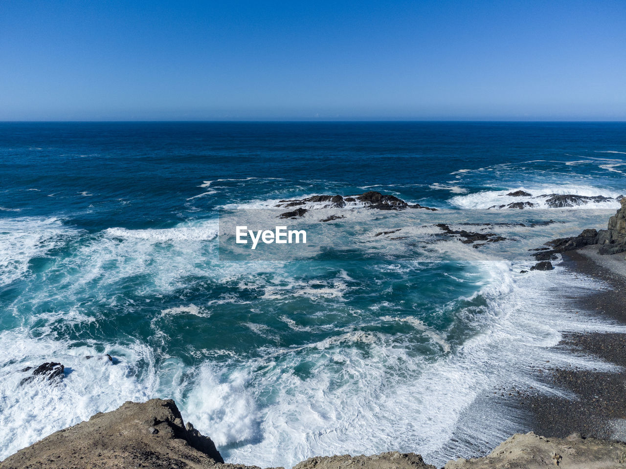sea, water, wave, land, beach, ocean, motion, wind wave, scenics - nature, beauty in nature, sky, shore, body of water, water sports, nature, horizon over water, coast, surfing, horizon, sports, rock, blue, clear sky, environment, outdoors, cliff, day, travel destinations, terrain, travel, coastline, idyllic, breaking, tranquility, splashing, seascape, landscape, tranquil scene, power in nature, tourism