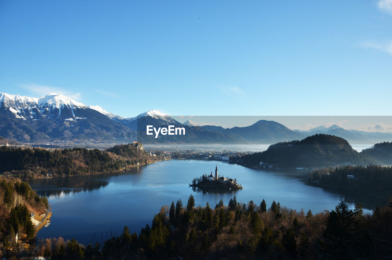 Scenic view of lake and mountains against blue sky