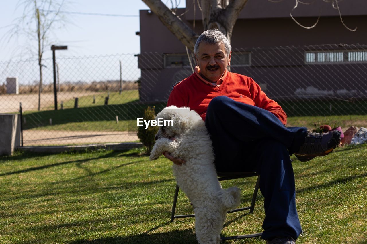 FULL LENGTH OF MAN WITH DOG ON FARM