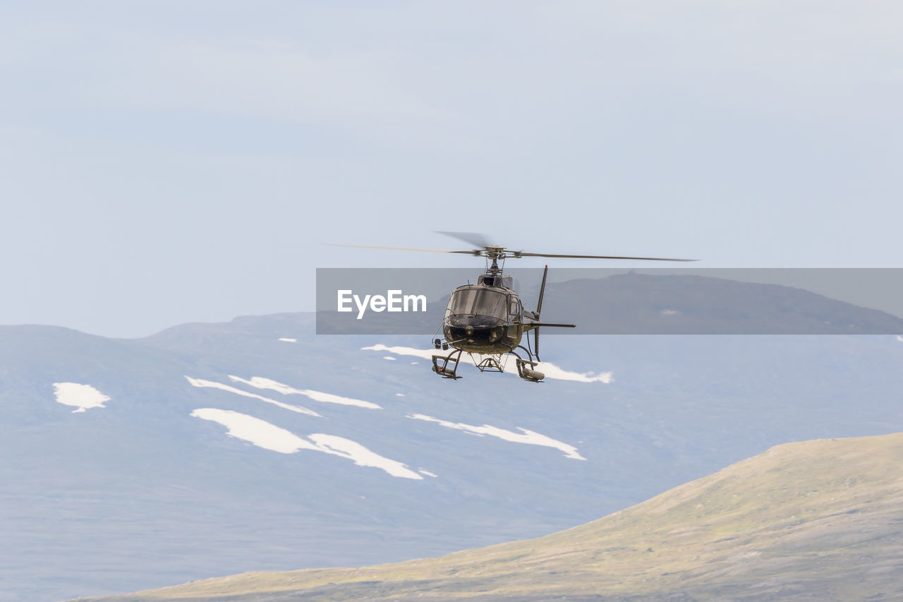 Helicopter in the sky in a mountain landscape
