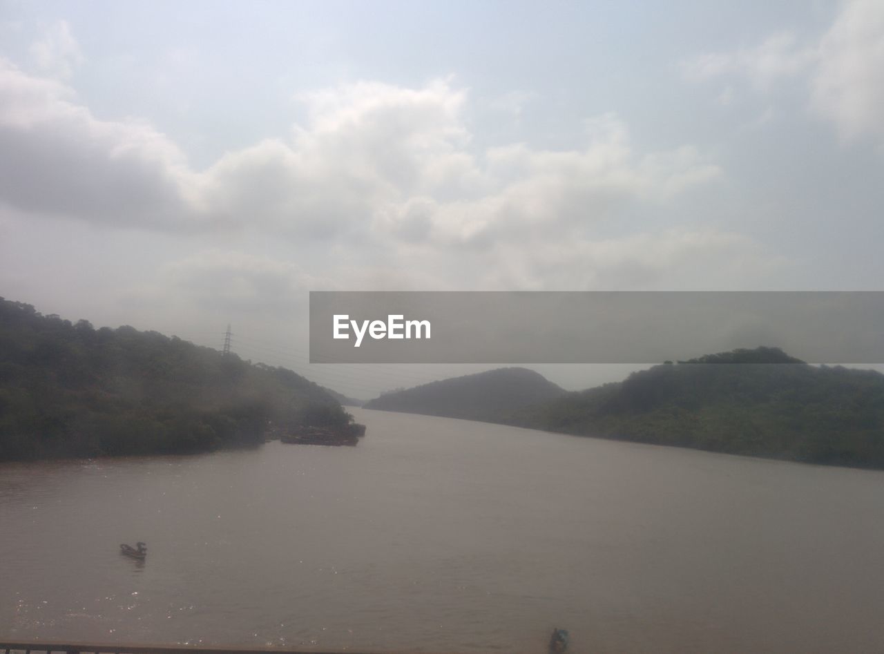 SCENIC VIEW OF LAKE BY MOUNTAIN AGAINST SKY