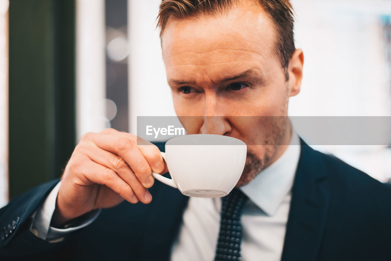 Mature businessman drinking coffee in cafe