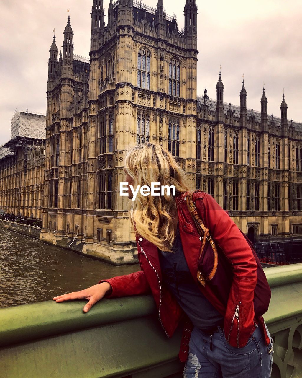 Young woman wearing leather jacket at westminster bridge in city