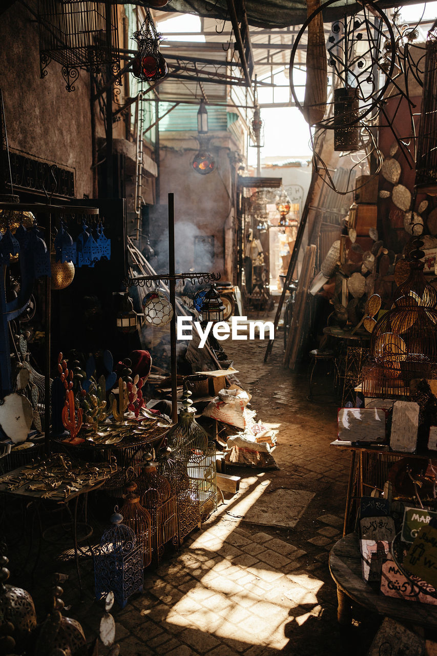 Narrow passage in typical marketplace with various colorful goods on street of old city marrakesh in morocco