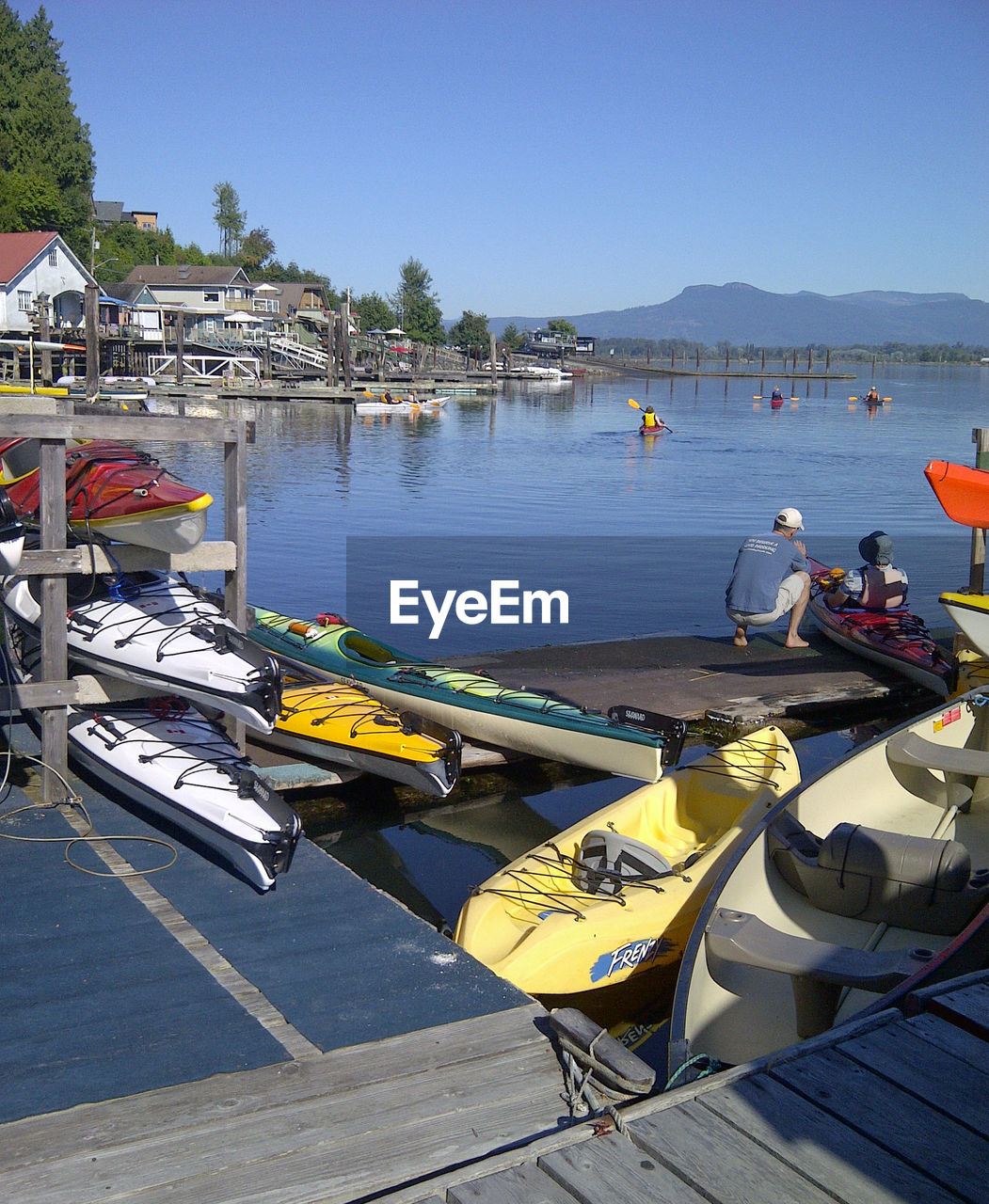 BOATS MOORED AT HARBOR AGAINST CLEAR SKY