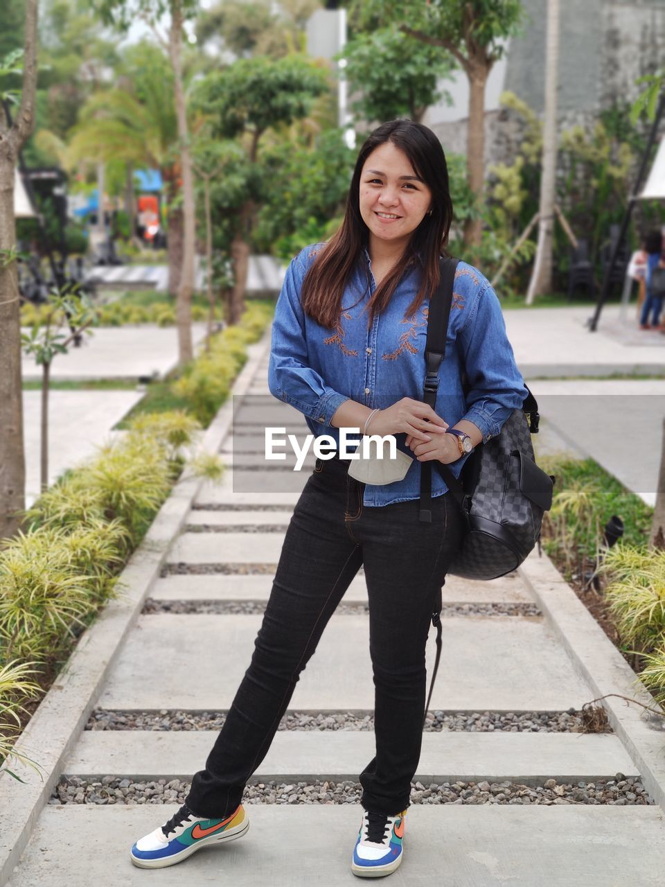 Full length of young woman walking on footpath