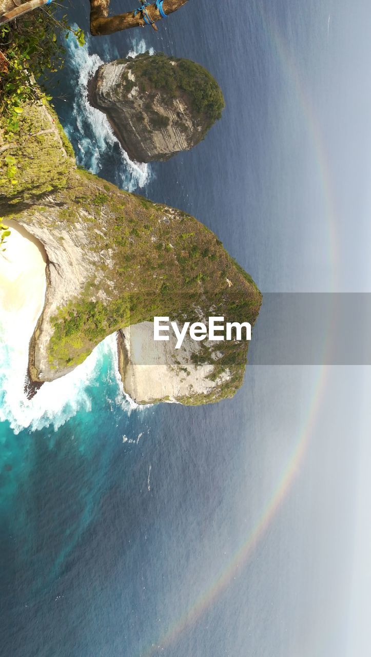 HIGH ANGLE VIEW OF RAINBOW ABOVE SEA