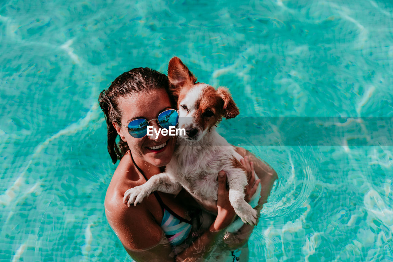 High angle view of woman with dog swimming in pool