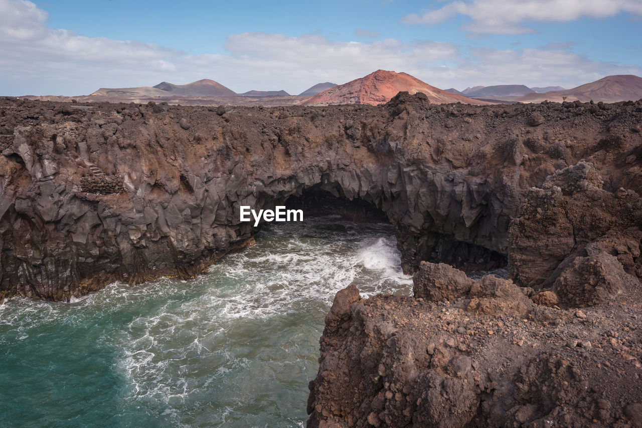 Scenic view of rocks in sea against sky