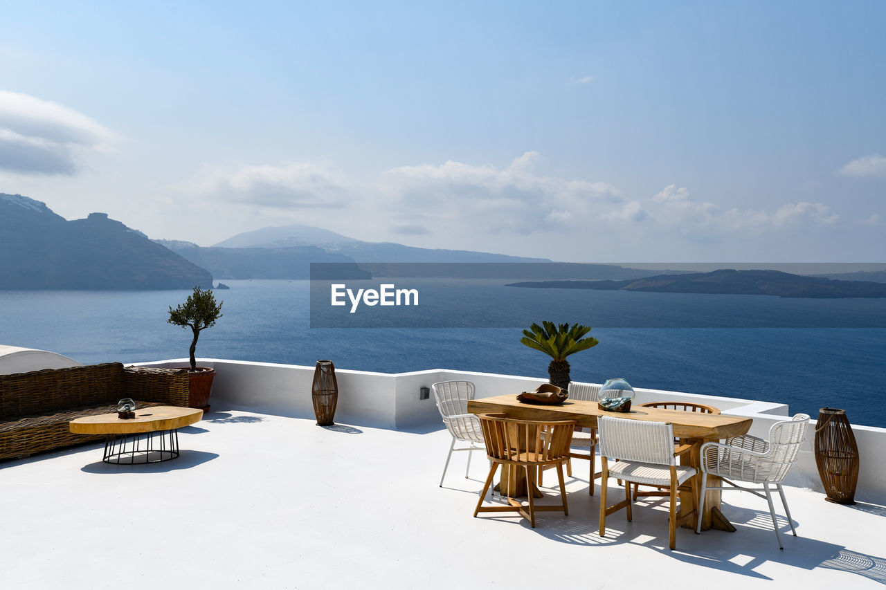 CHAIRS BY SWIMMING POOL AGAINST SKY