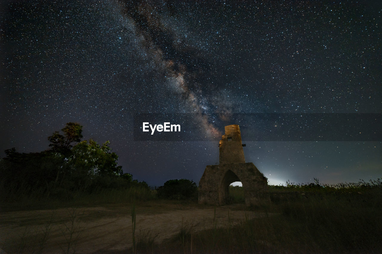 Panorama of an old tower during a starry night with the milky way