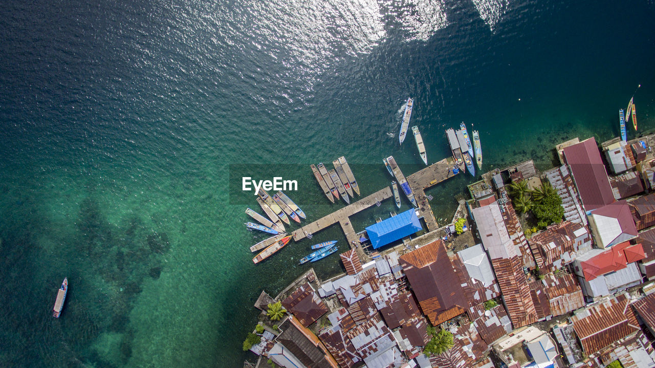 Aerial view of boats moored at harbor in sea