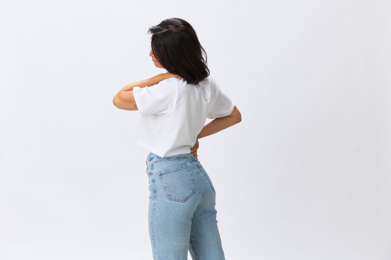side view of woman standing against white background
