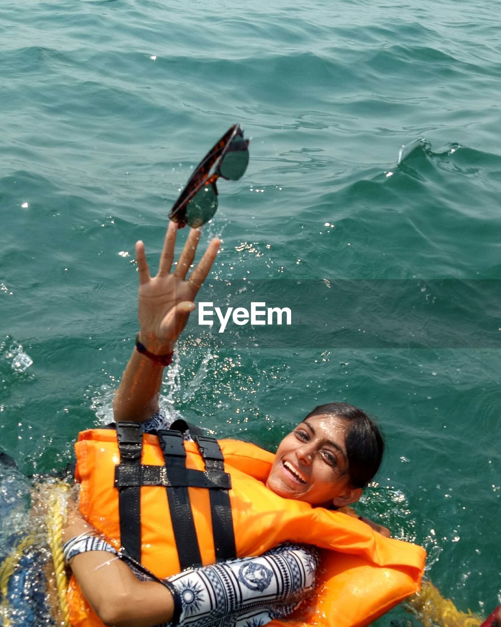High angle view of woman wearing life jacket swimming in sea