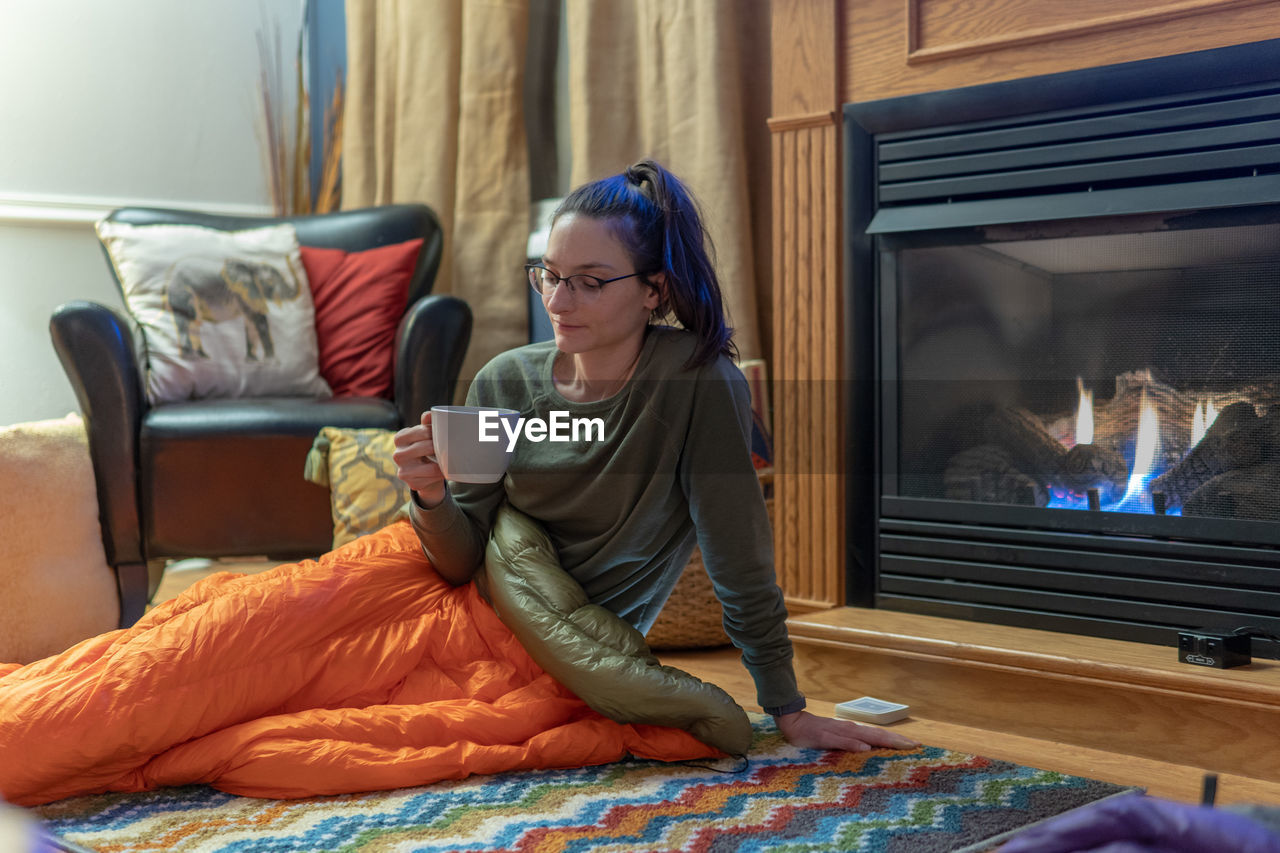 WOMAN SITTING ON SOFA AT HOME