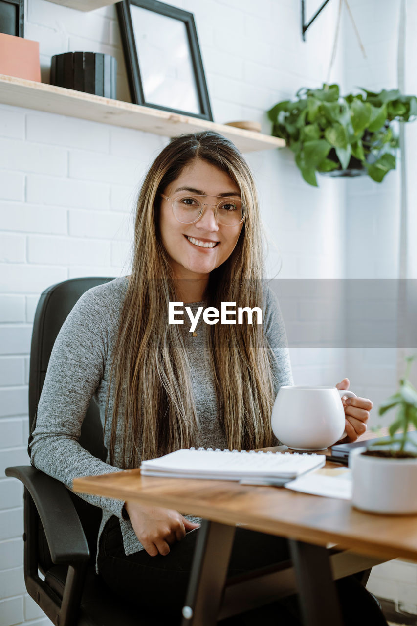 Mexican young woman works with natural pose in her home office