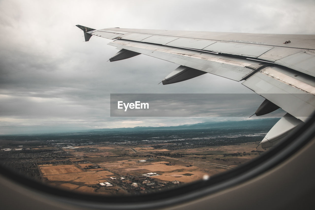 AERIAL VIEW OF AIRCRAFT WING OVER LANDSCAPE