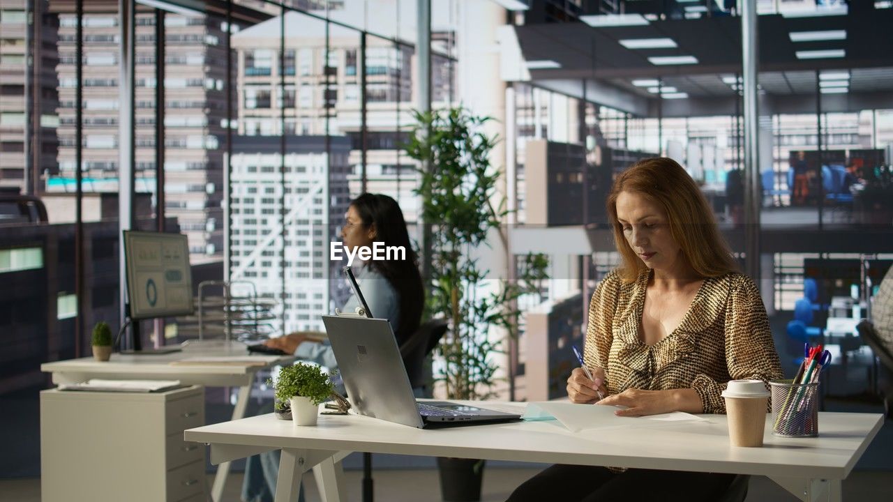 young woman using digital tablet while sitting in cafe