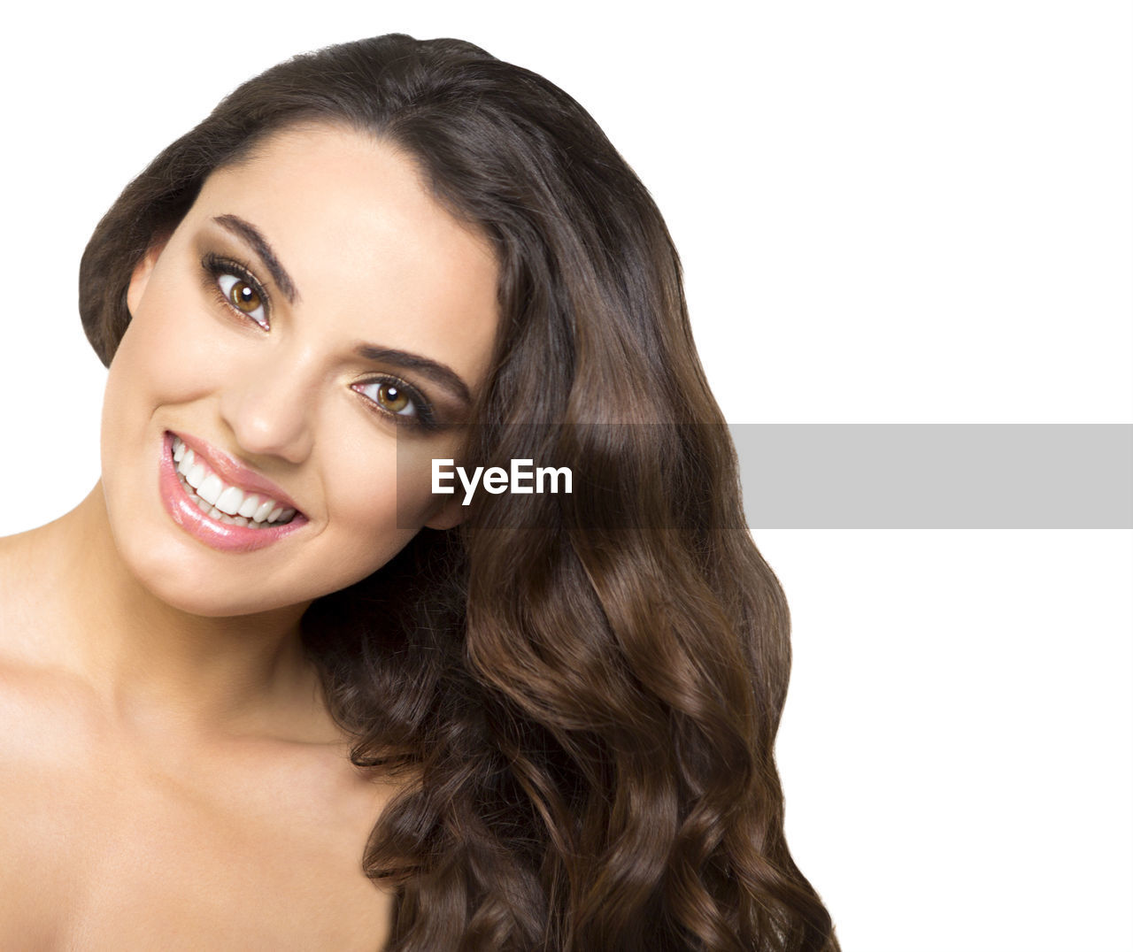 PORTRAIT OF SMILING YOUNG WOMAN AGAINST WHITE BACKGROUND