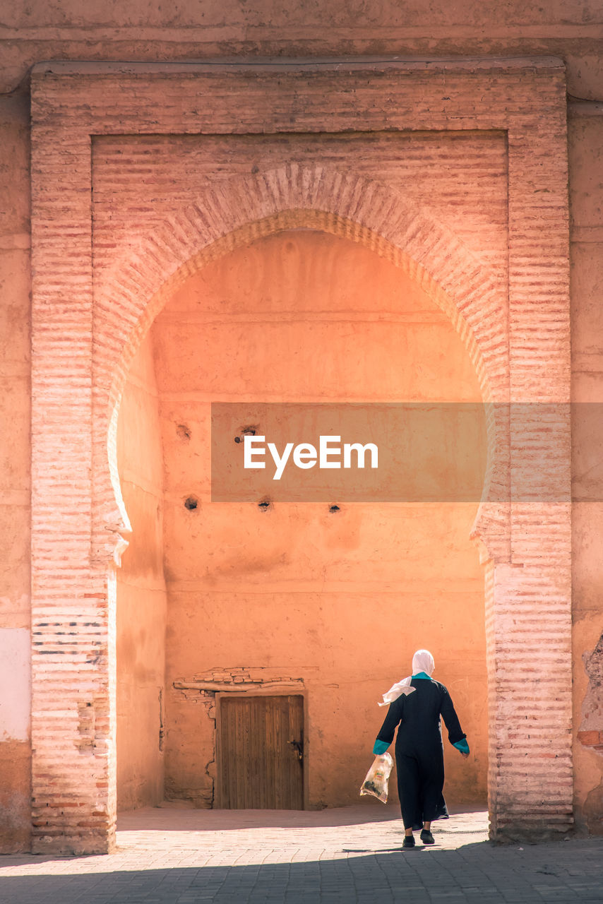 Woman walking through an arch in marrakesh