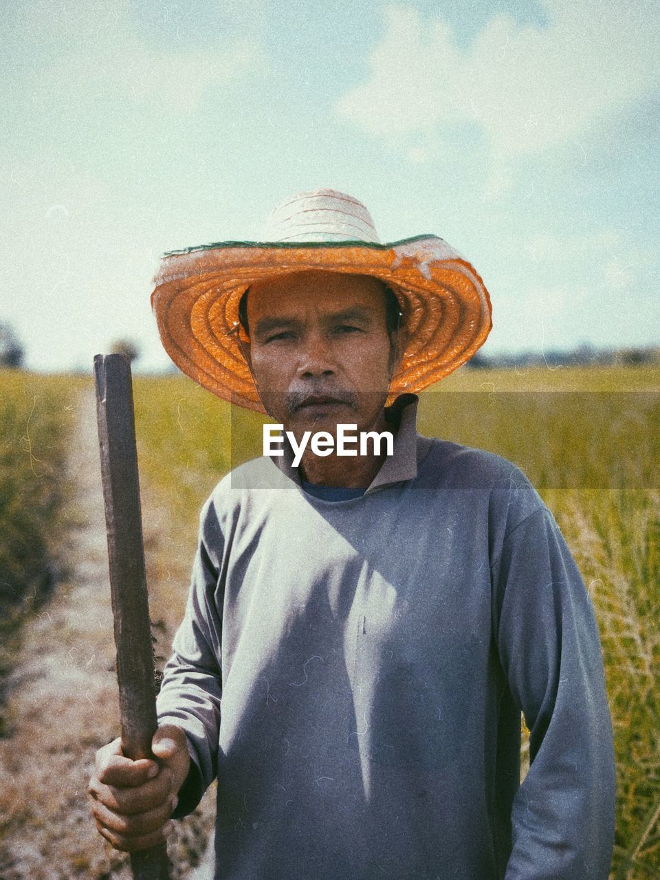 Portrait of man wearing hat standing on field