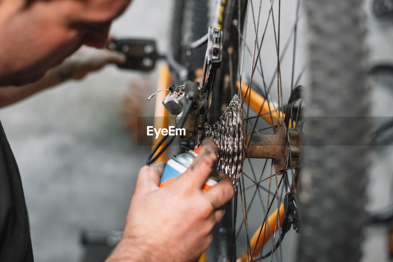 Cropped image of man repairing bicycle at workshop